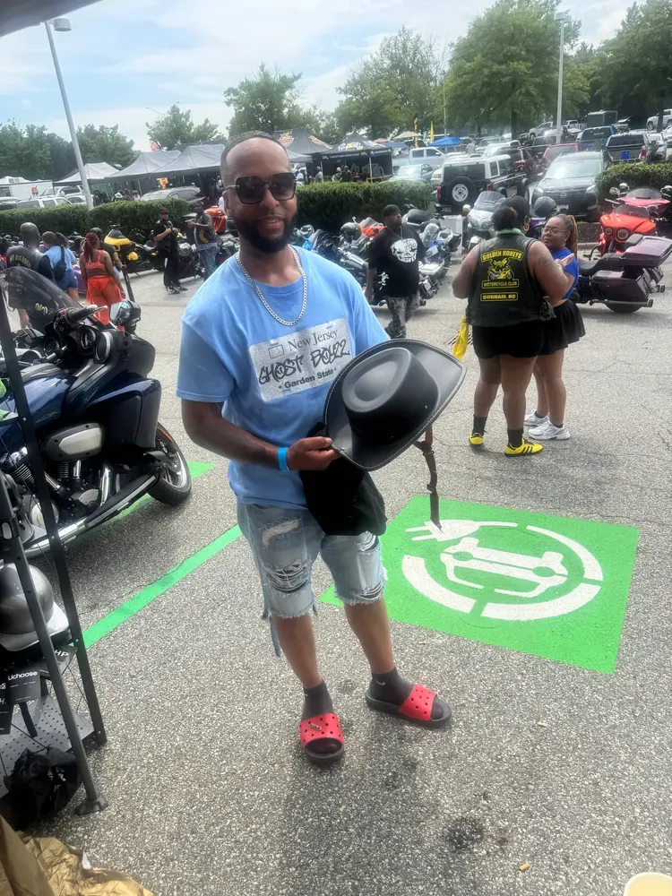 Rider standing among motorcycles at an outdoor event