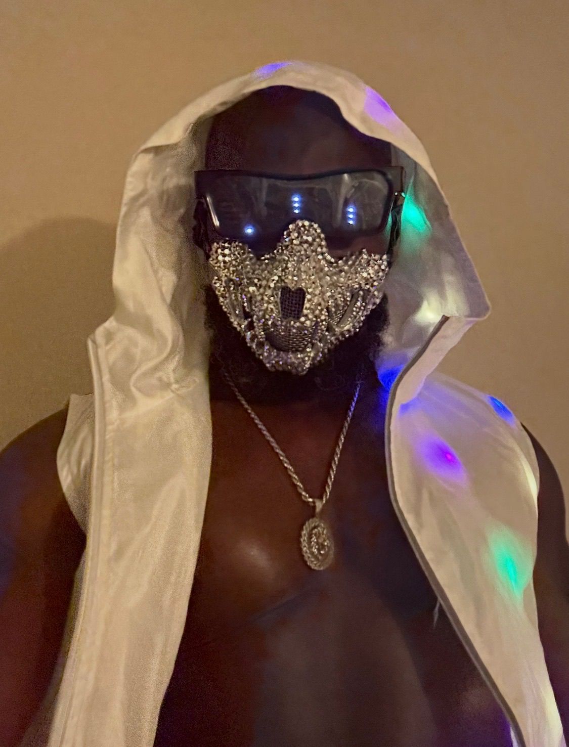 Customer wearing a light-up silver embellished mask and white hooded look