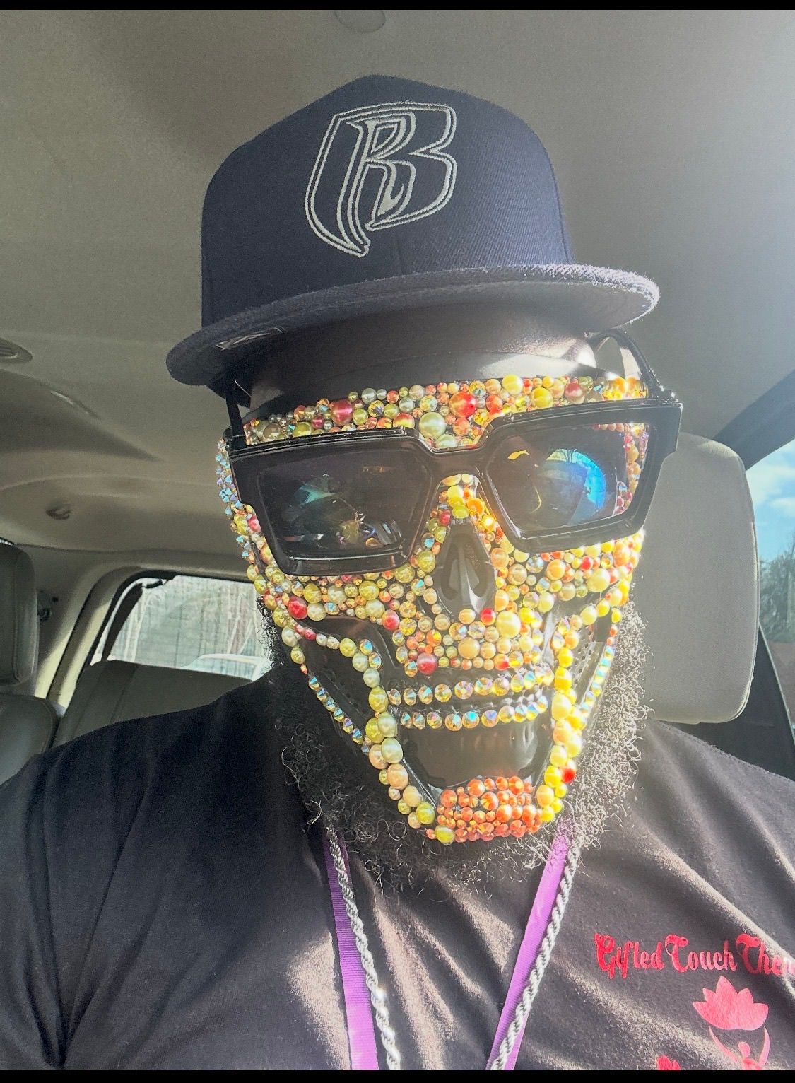 Customer wearing a colorful crystal skull mask inside a vehicle