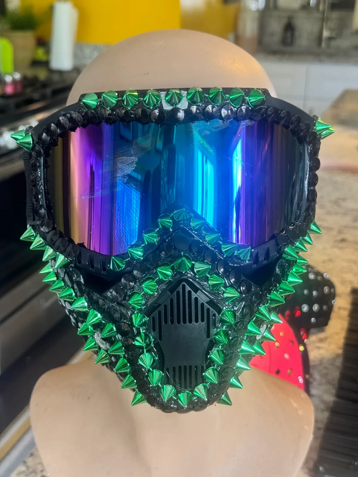 Close home view of the Green Goblin spiked mask with emerald studs and rainbow visor
