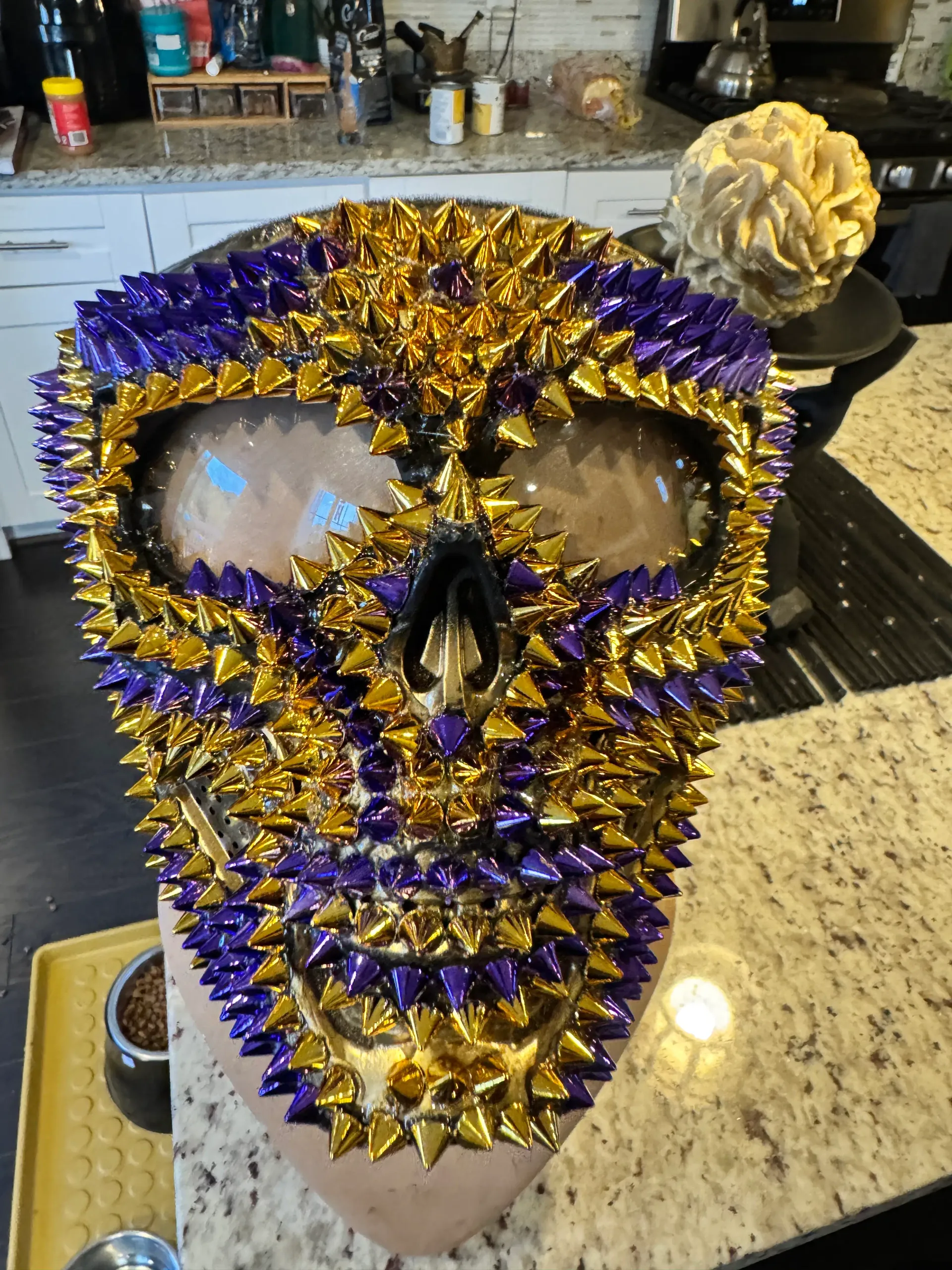 Front view of a purple and gold spiked mask on a mannequin