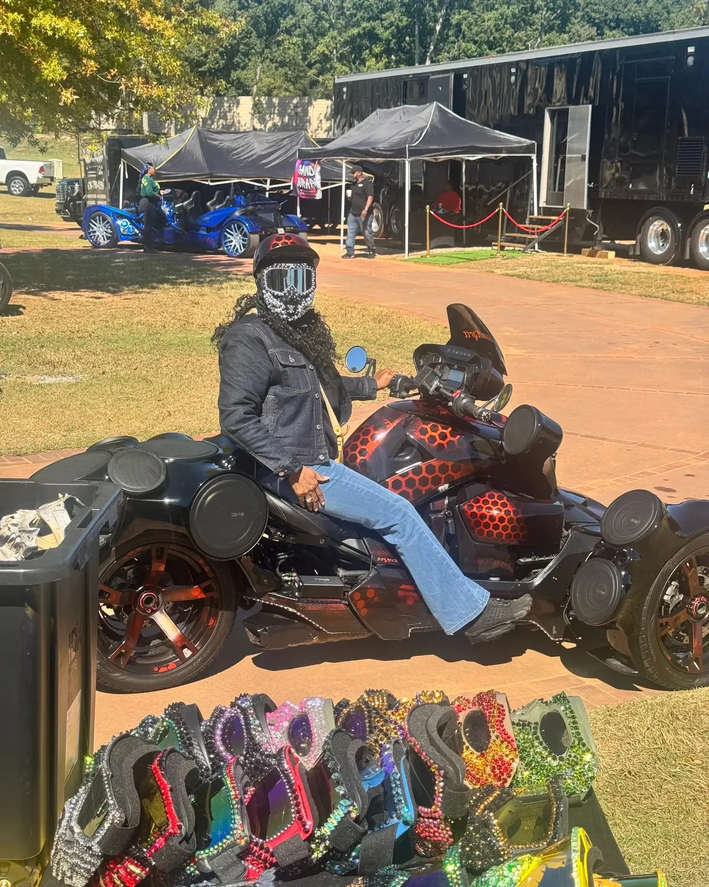 FAB N THINGZ rider in a multicolor crystal skull mask giving a peace sign from her bike